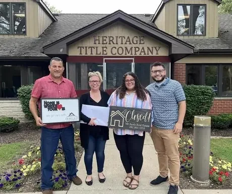 Family holding Closed sign outside the title company
