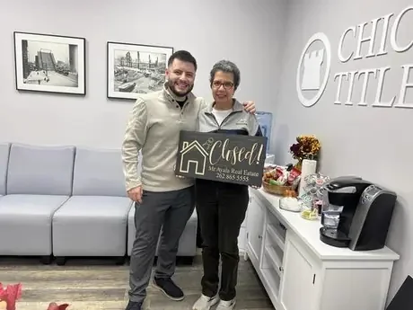 Client holding the Closed sign at the title office